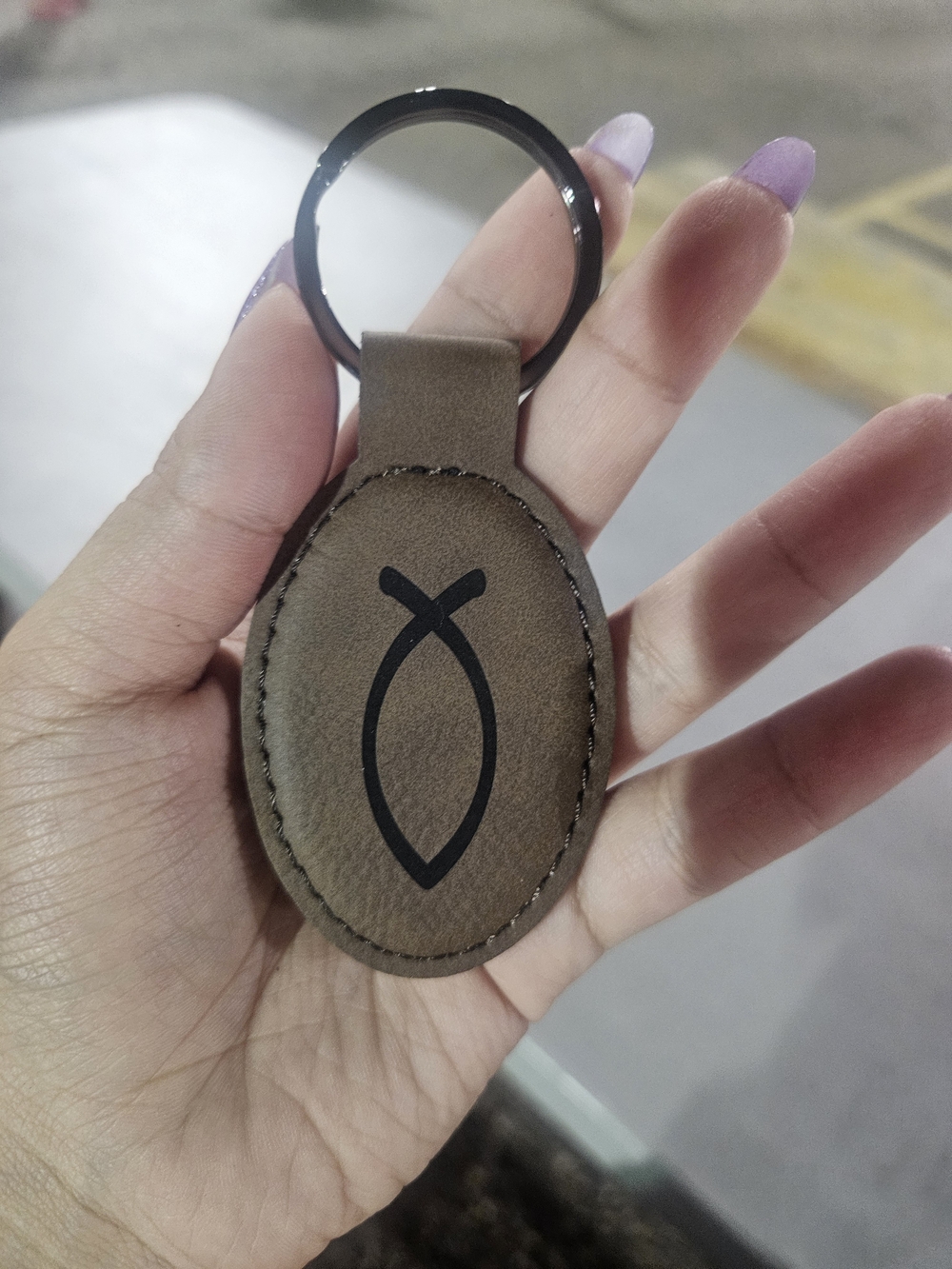 Oval Brown Leather Keychain with Black Fish Emblem